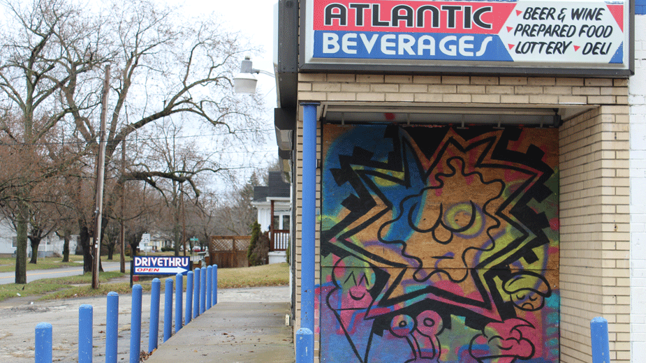 The front door of the shuttered Atlantic Beverages in Warren, Ohio has been painted in bright orange and blue and covered in stars and ice cream cones