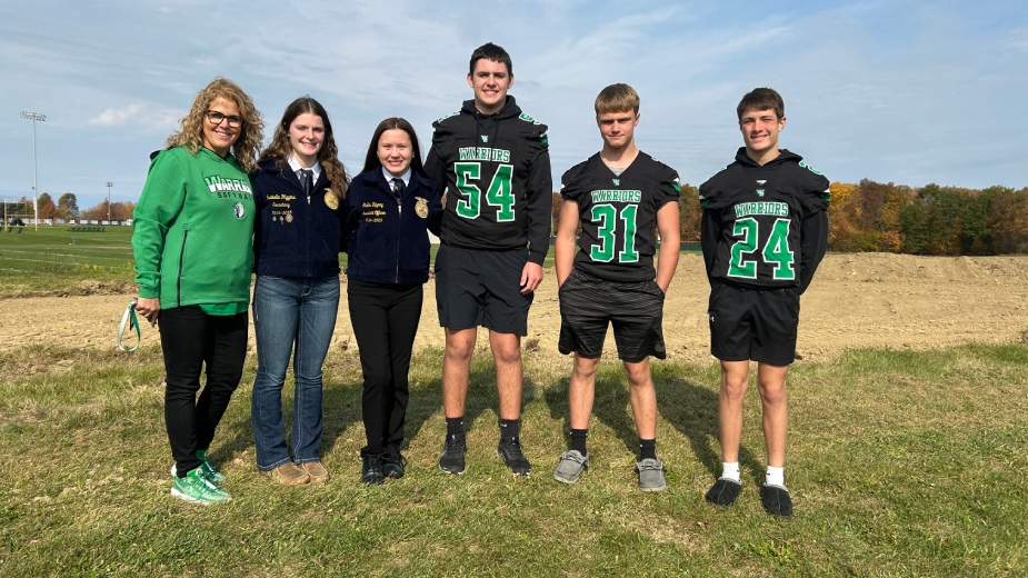 West Branch Local School District Superintendent Micki Egli and students Isabella Higgins, Stella Zippay, Grady Rockwell, Owen Bloss and Case Sanor stand behind the high school where grading is underway to build an animal husbandry barn, beginning this spring.